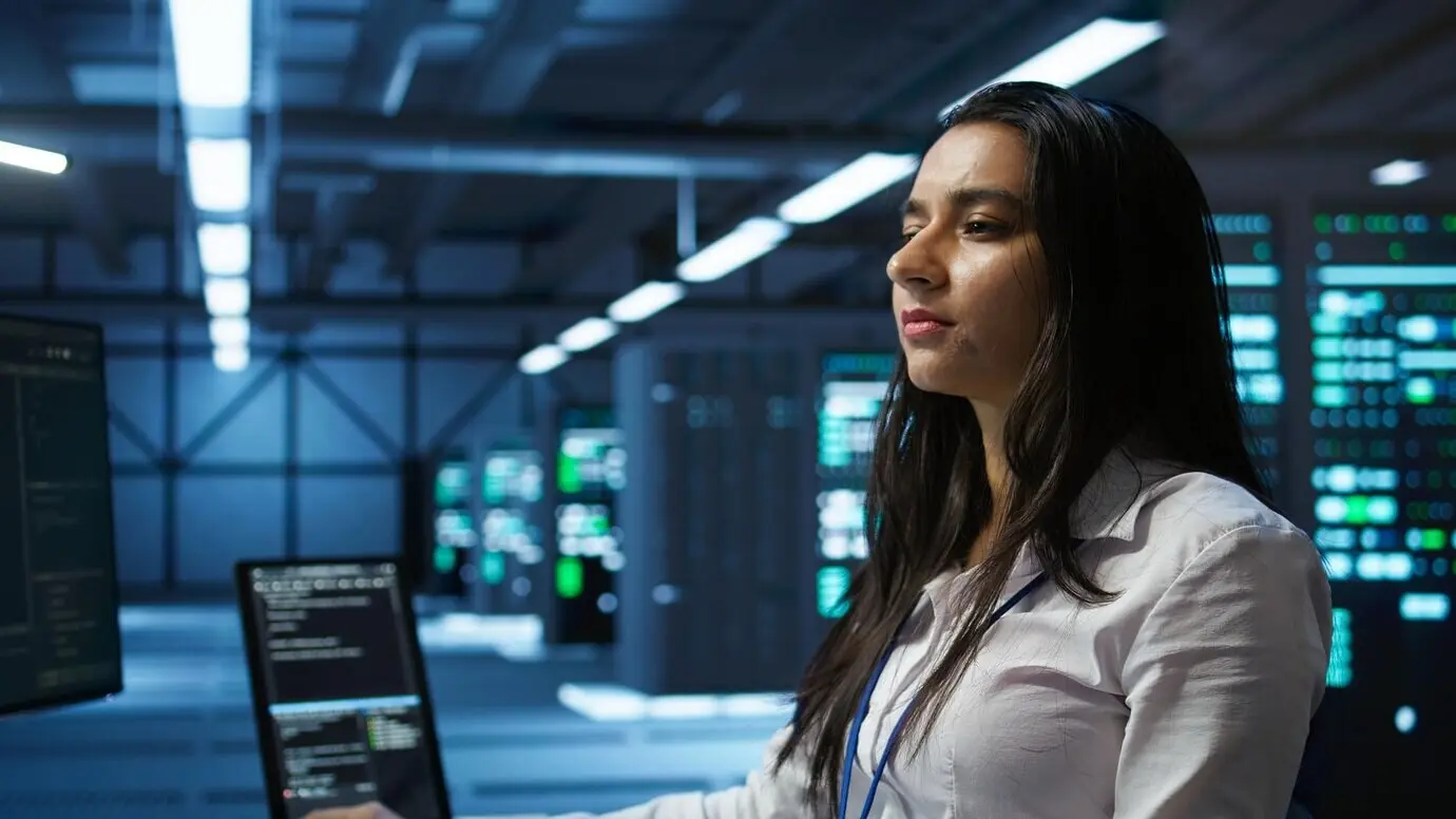 Специалист по информатике в дата-центре отслеживает угрозы безопасности с помощью компьютера.